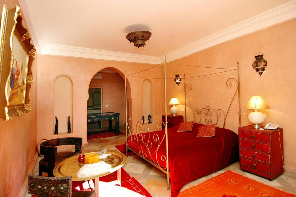 Traditional Moroccan inspired bedroom with warm walls, ornate lighting, and cultural accents